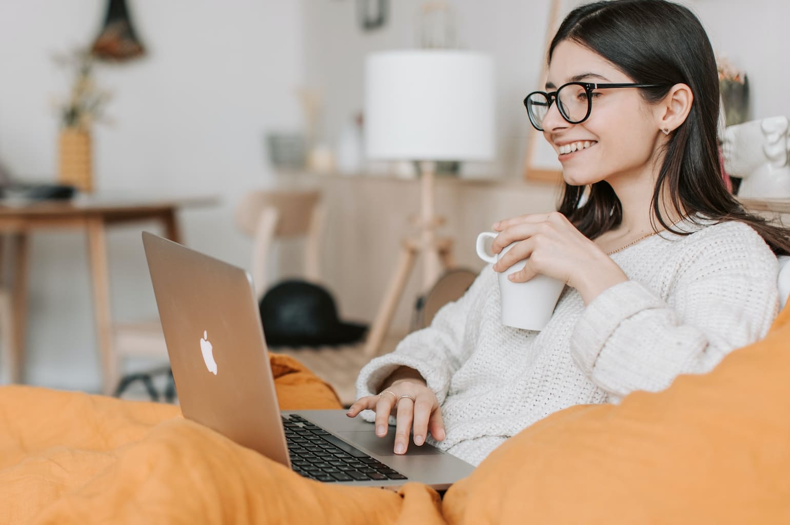 donna che cerca al computer come vendere per comprare casa con una tazza in mano